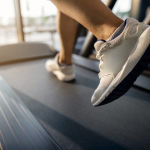 Close-up of sportswoman jogging on running track at health club.