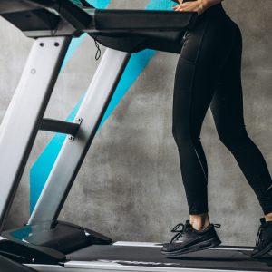 Female legs on the running track at the gym